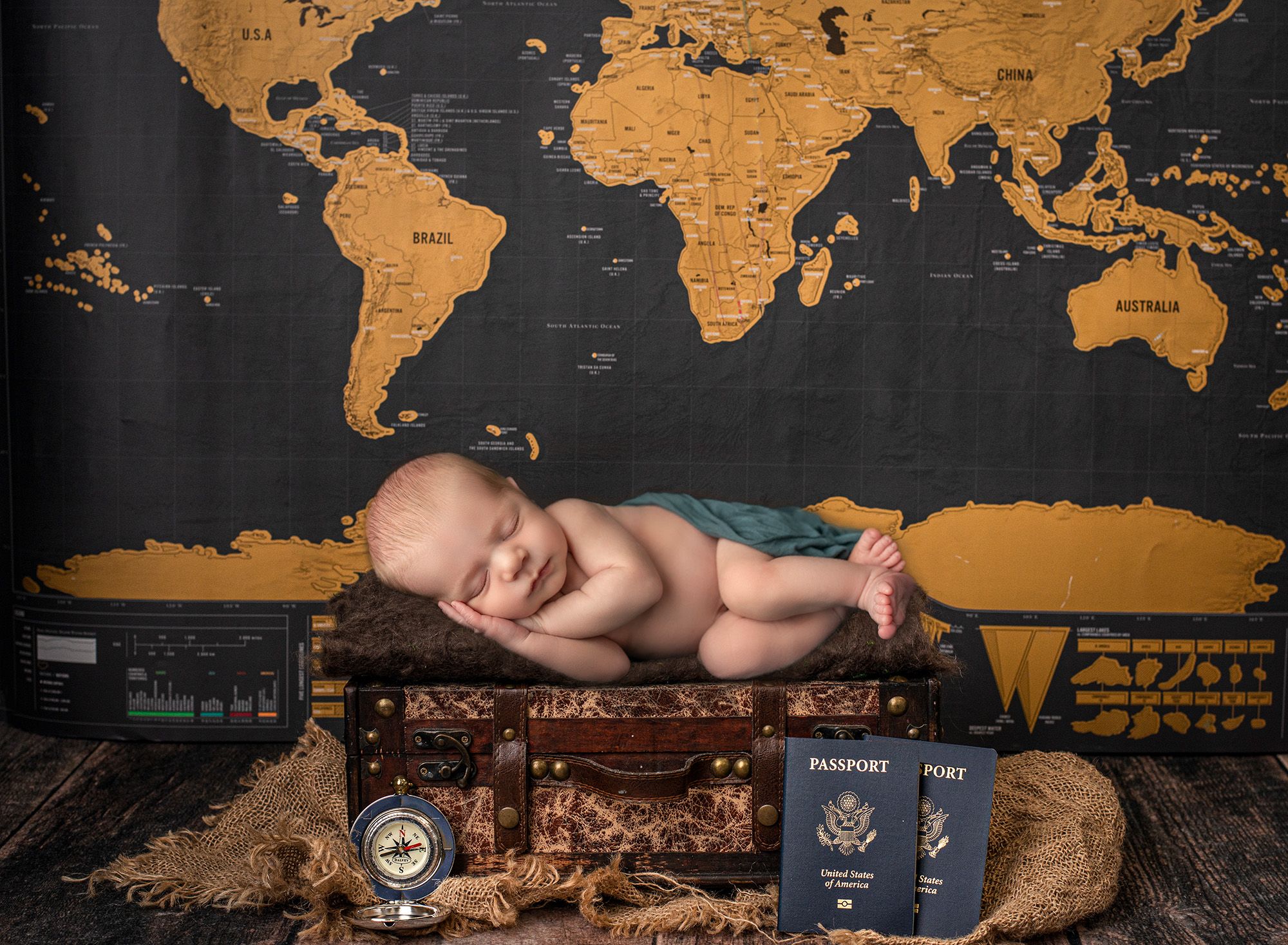 Glastonbury Newborn Photographer newborn baby boy asleep on rustic trunk surrounded by world map and transports