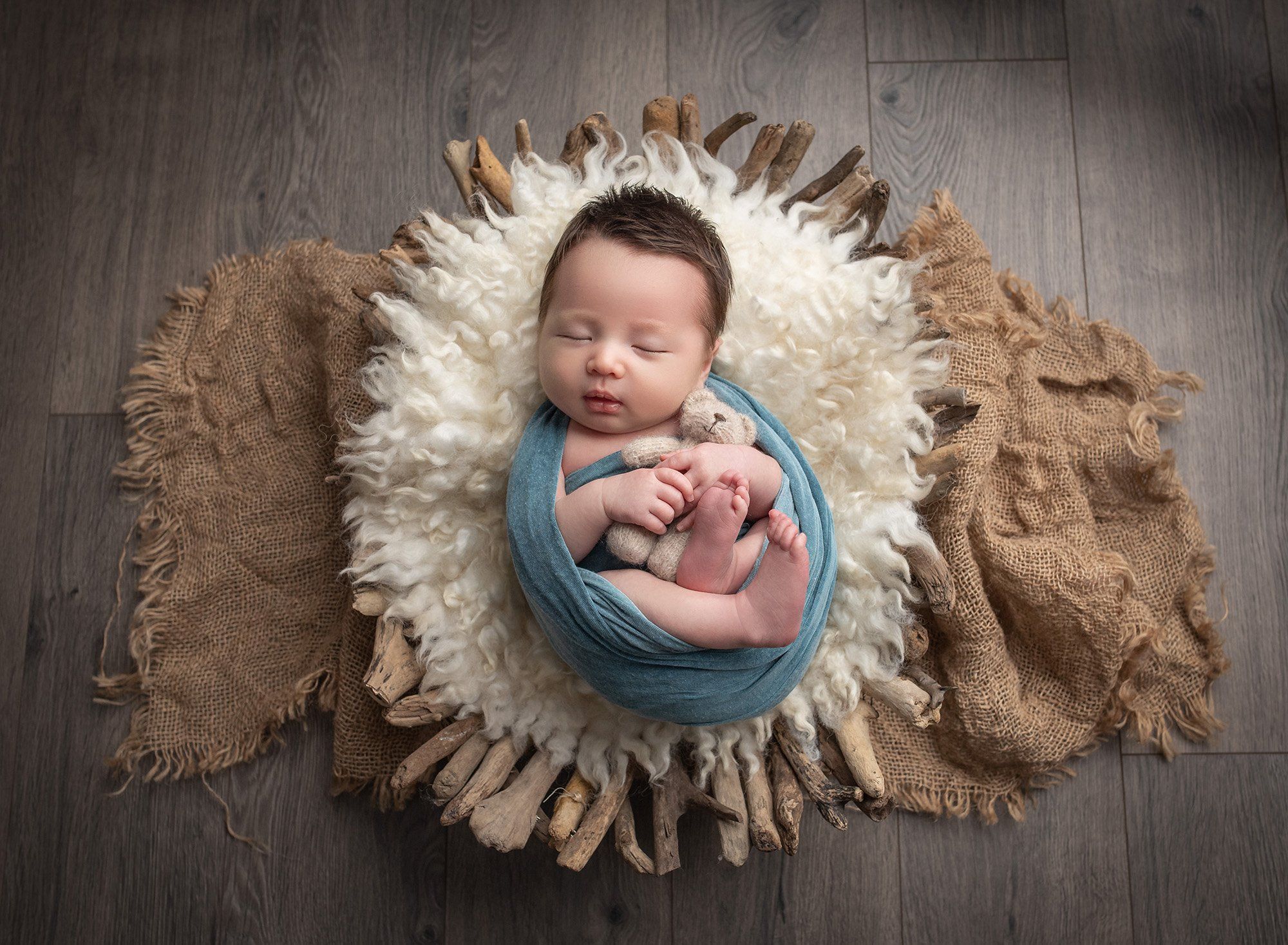 best time to do newborn photos newborn baby boy swaddled in teal with his teddy bear in a driftwood bowl best time to take newborn photos