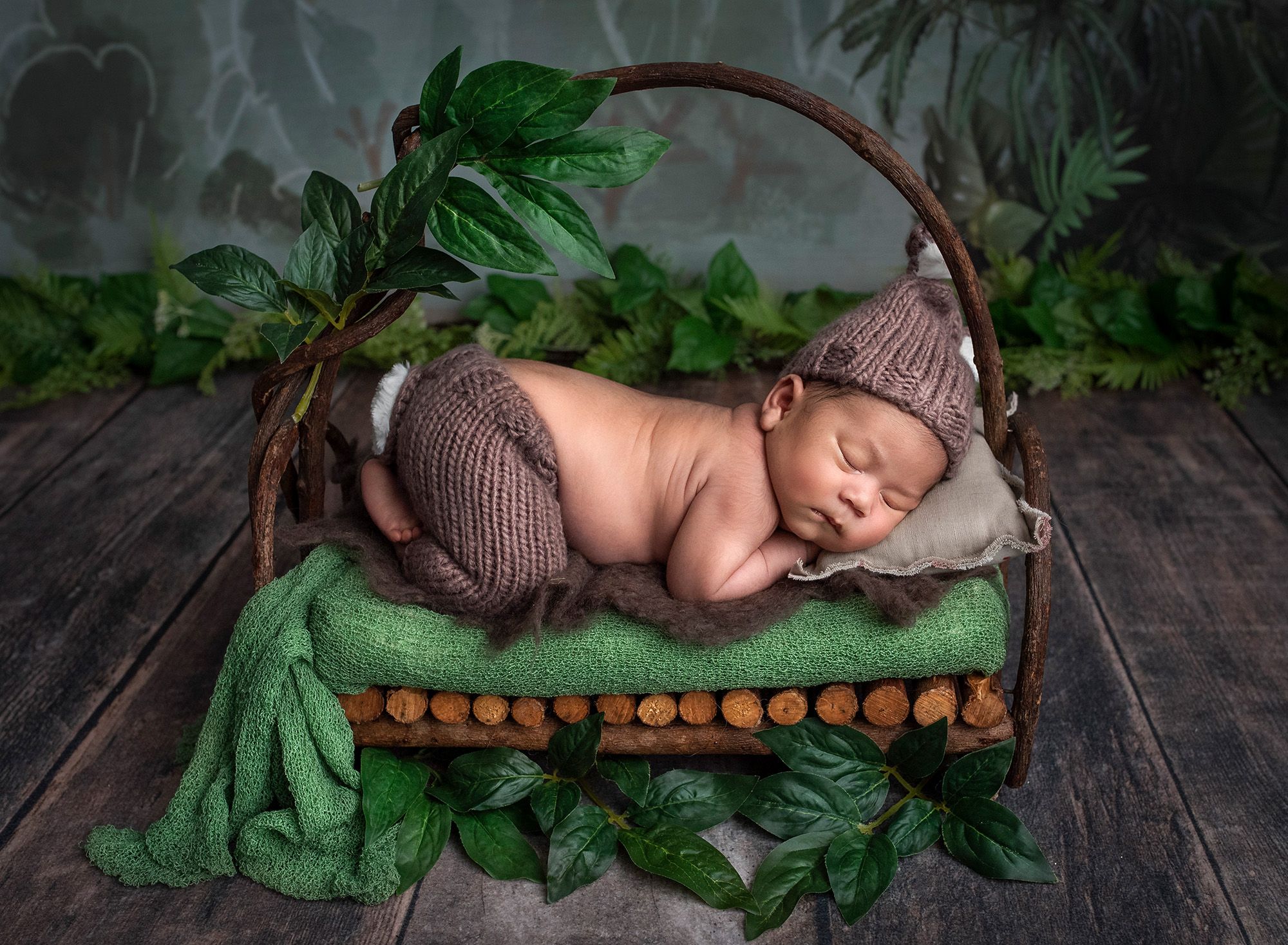 Newborn photos with Thai culture newborn baby boy asleep on wooden bed in the forest