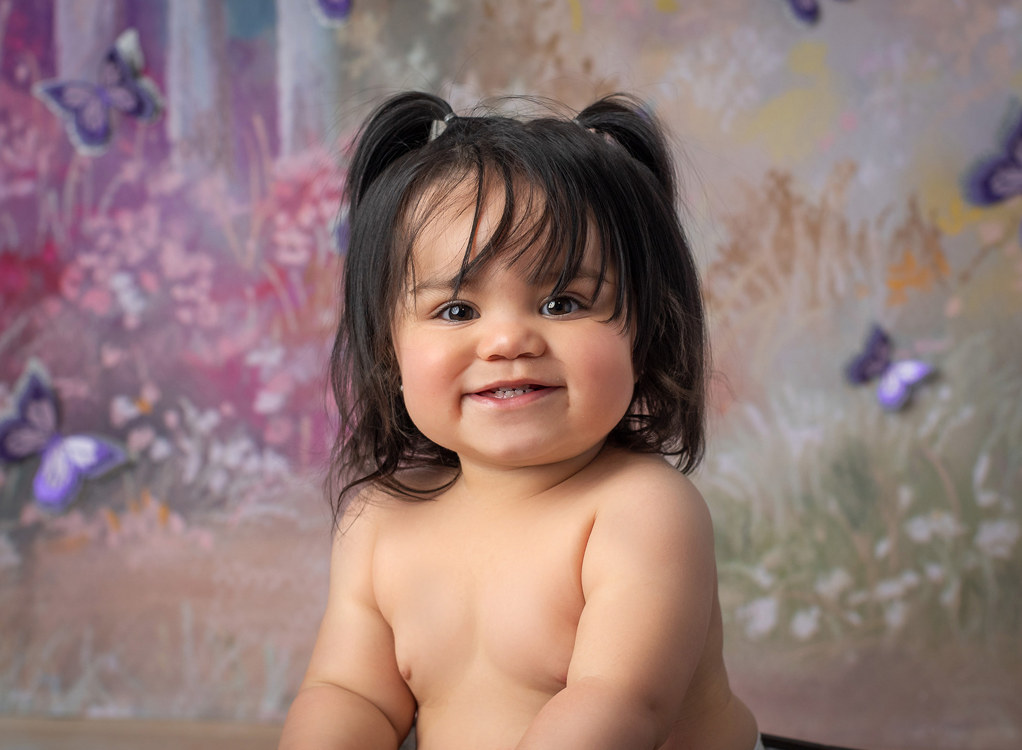 One Year Old Photo Session one year old baby girl in pigtails smiling with butterflies in background