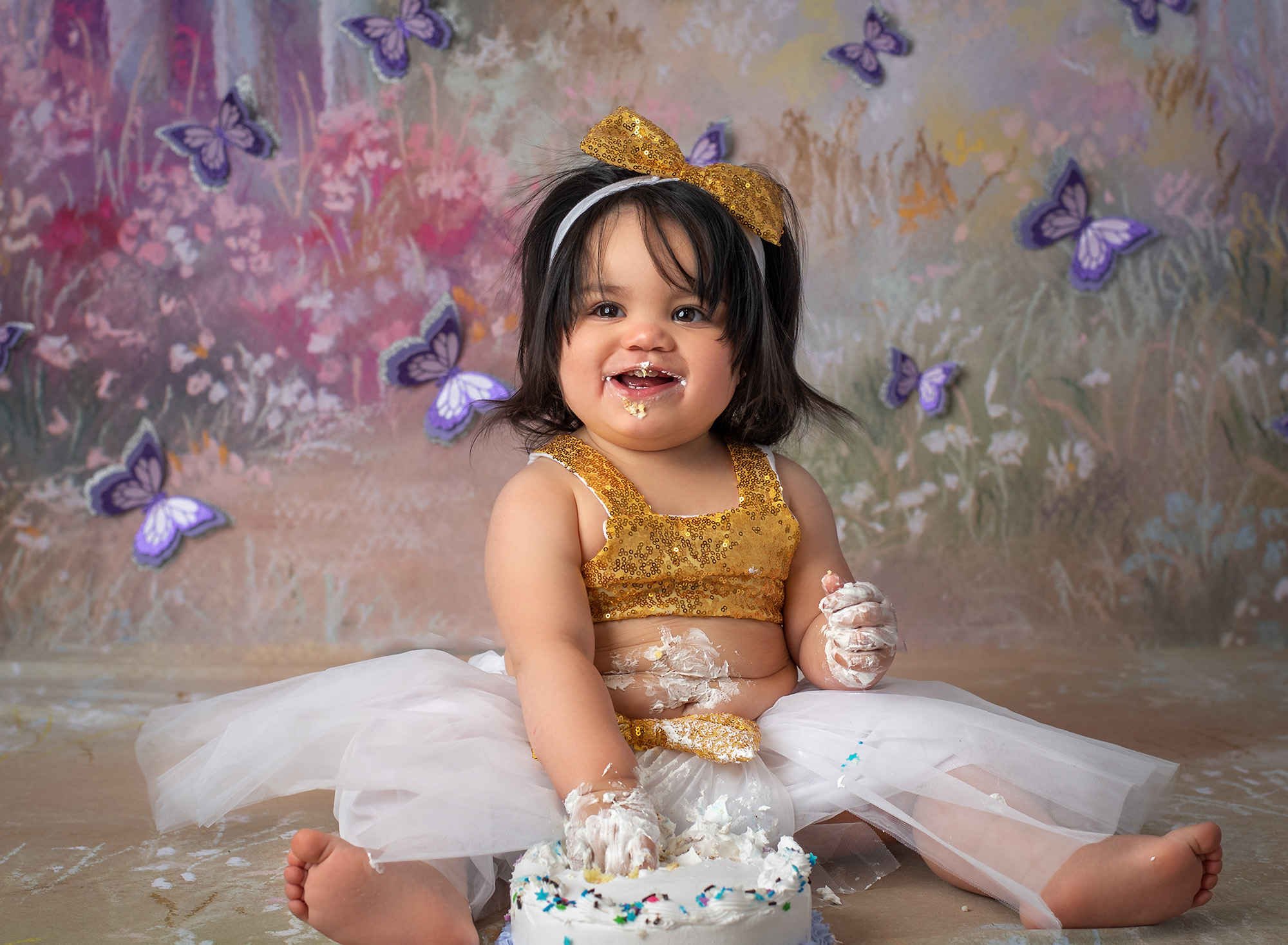 Butterfly Cake Smash Pictures one year old girl covered in cake with butterfly background