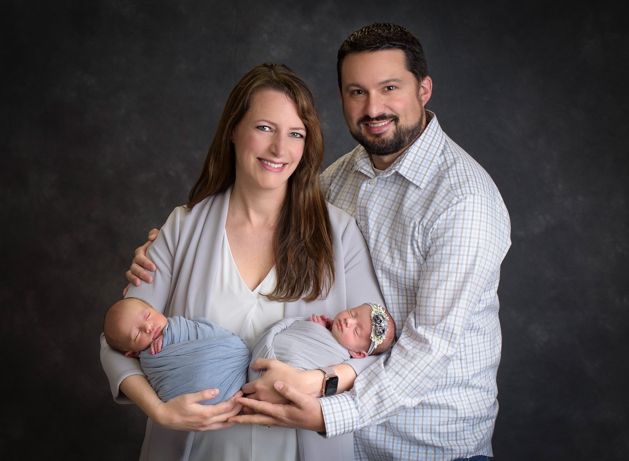 new parents cradling their newborn baby boy and girl