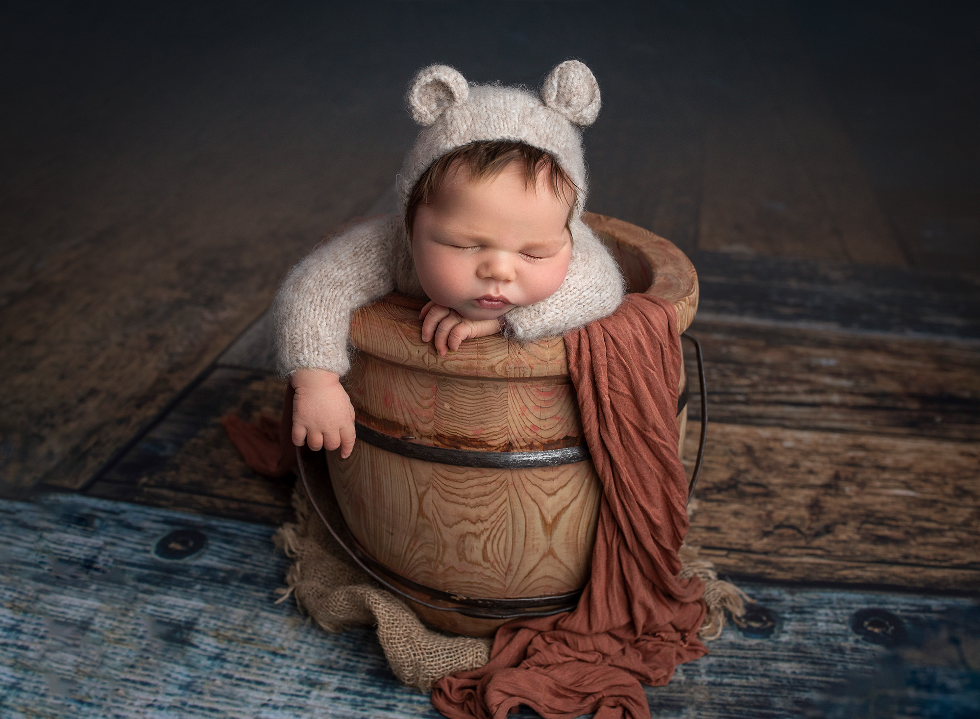 Connecticut Newborn Photography newborn baby boy dressed in bear sweater romper sleeping inside honey pot