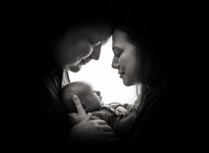silhouette shadow of parents face's while cradling their newborn baby boy