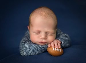 newborn photograph with a tiny football