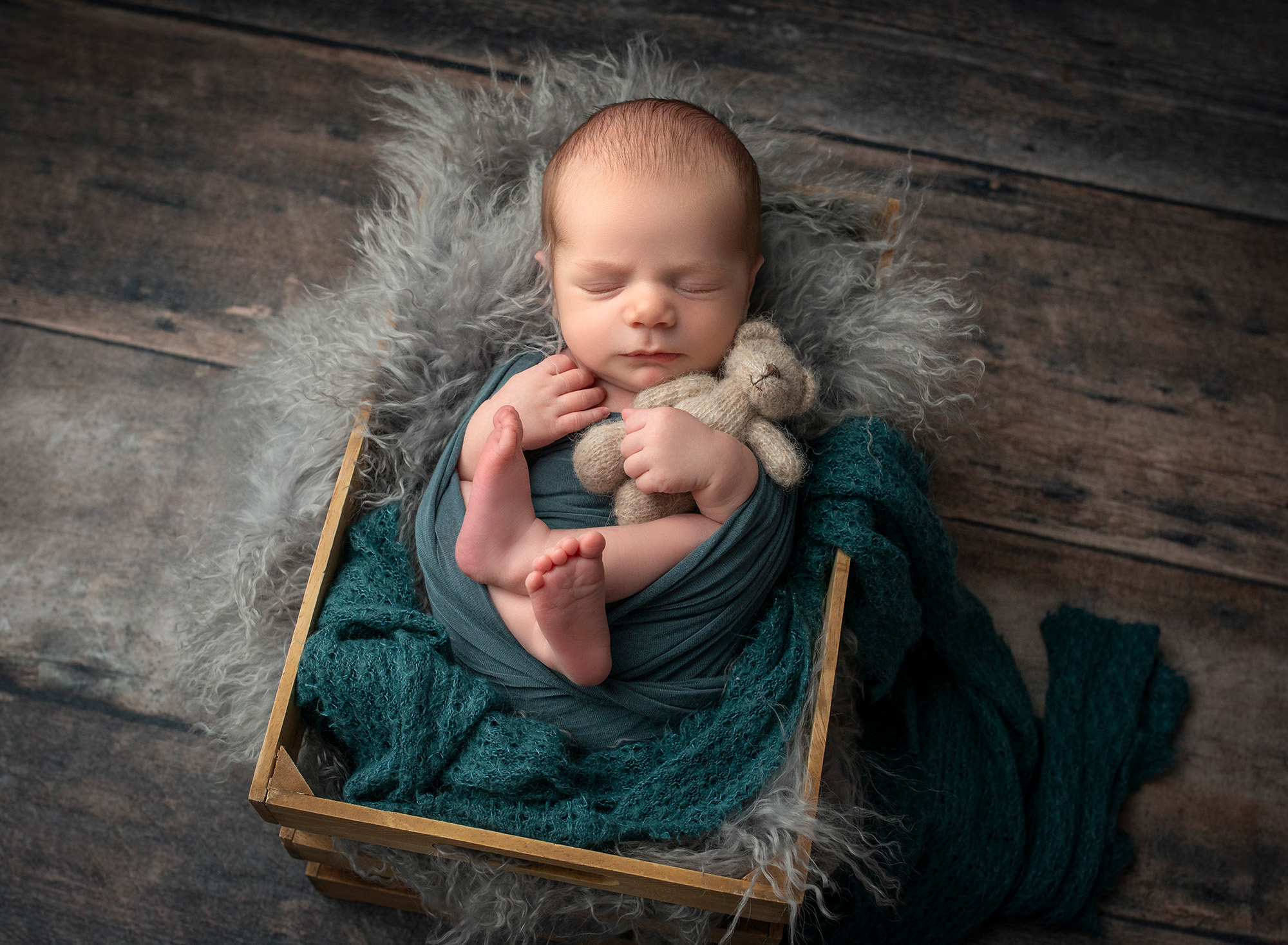 Glastonbury newborn photographer newborn baby boy asleep in rustic crate cuddling teddy bear