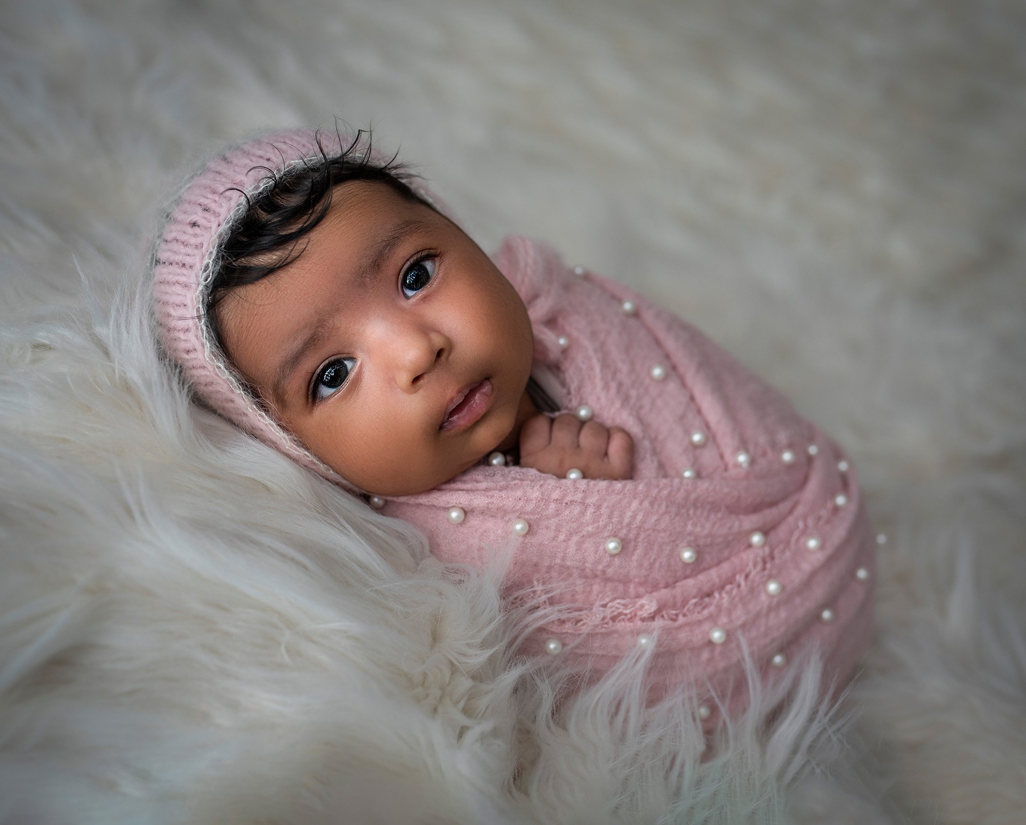 Newborn Girl Photography awake newborn girl swaddled in pink blanket with pearls