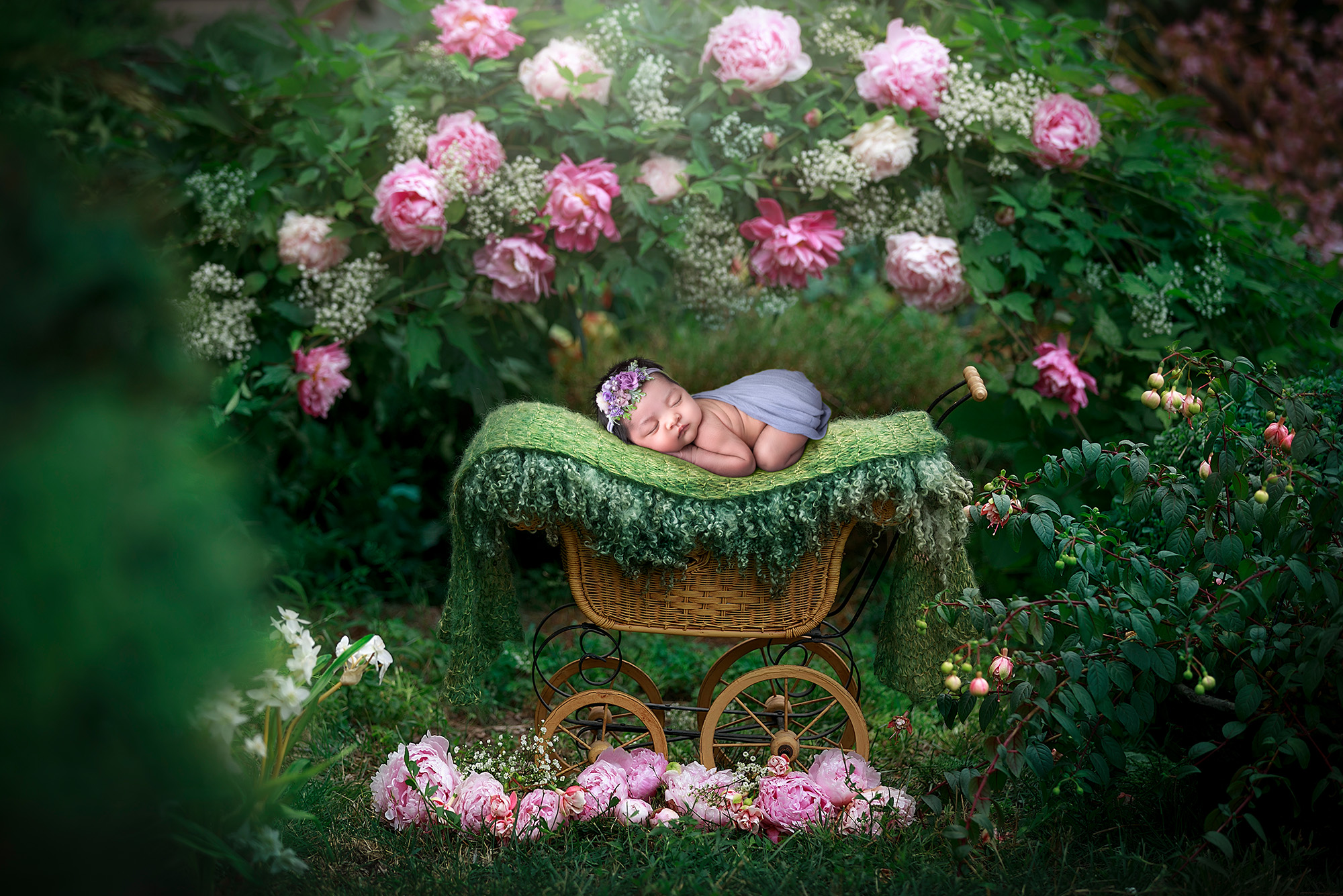 Newborn Photos Full of Color newborn baby girl sound asleep on wooden carriage in a forest of pink flowers