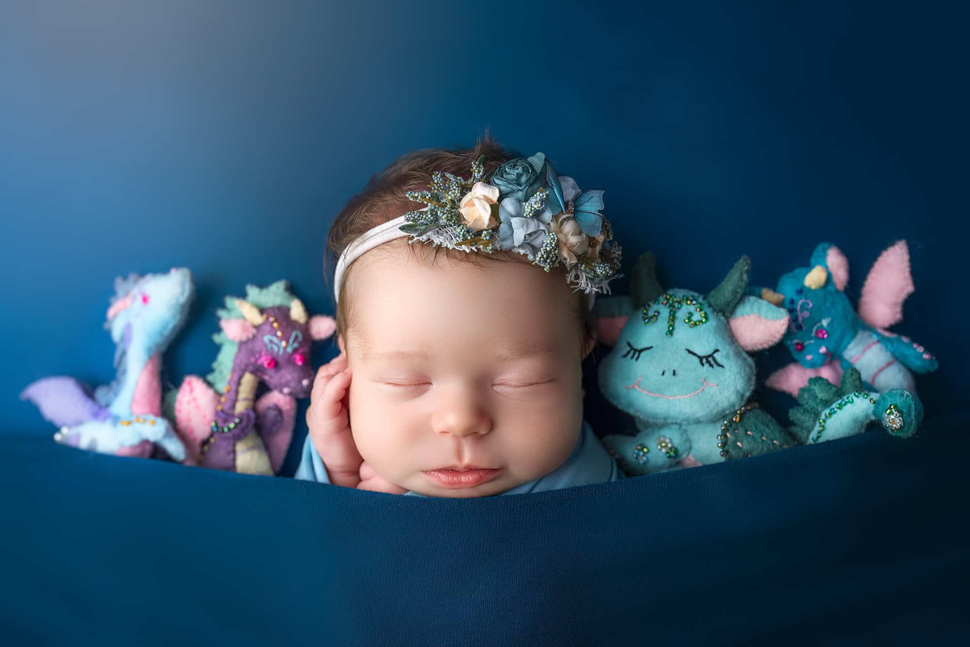 CT newborn photography newborn baby sleeping with baby dragon toys tucked in with her