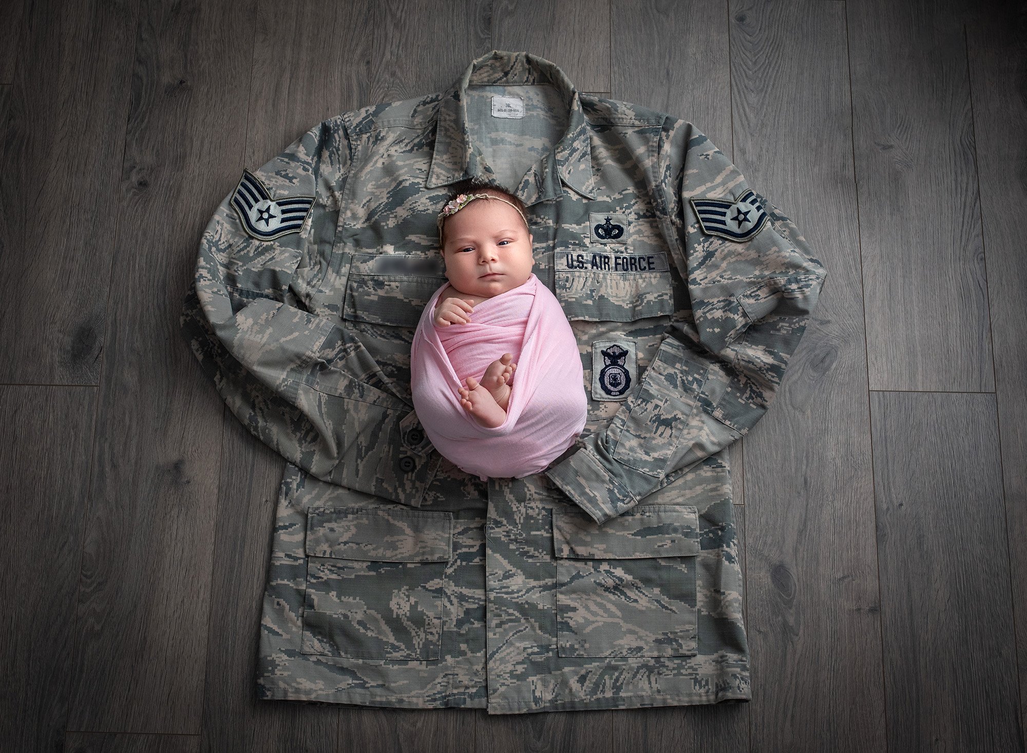 Deployed Military Newborn Photo newborn baby girl swaddled on top of her deployed dad's Air Force uniform