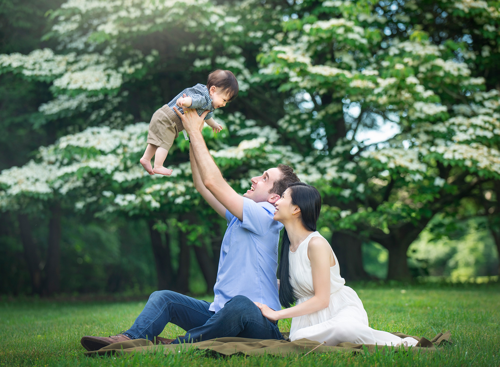 connecticut baby photographer couple posing while dad holds toddler up in the air