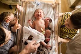 hospital newborn photographer baby crying in bassinett